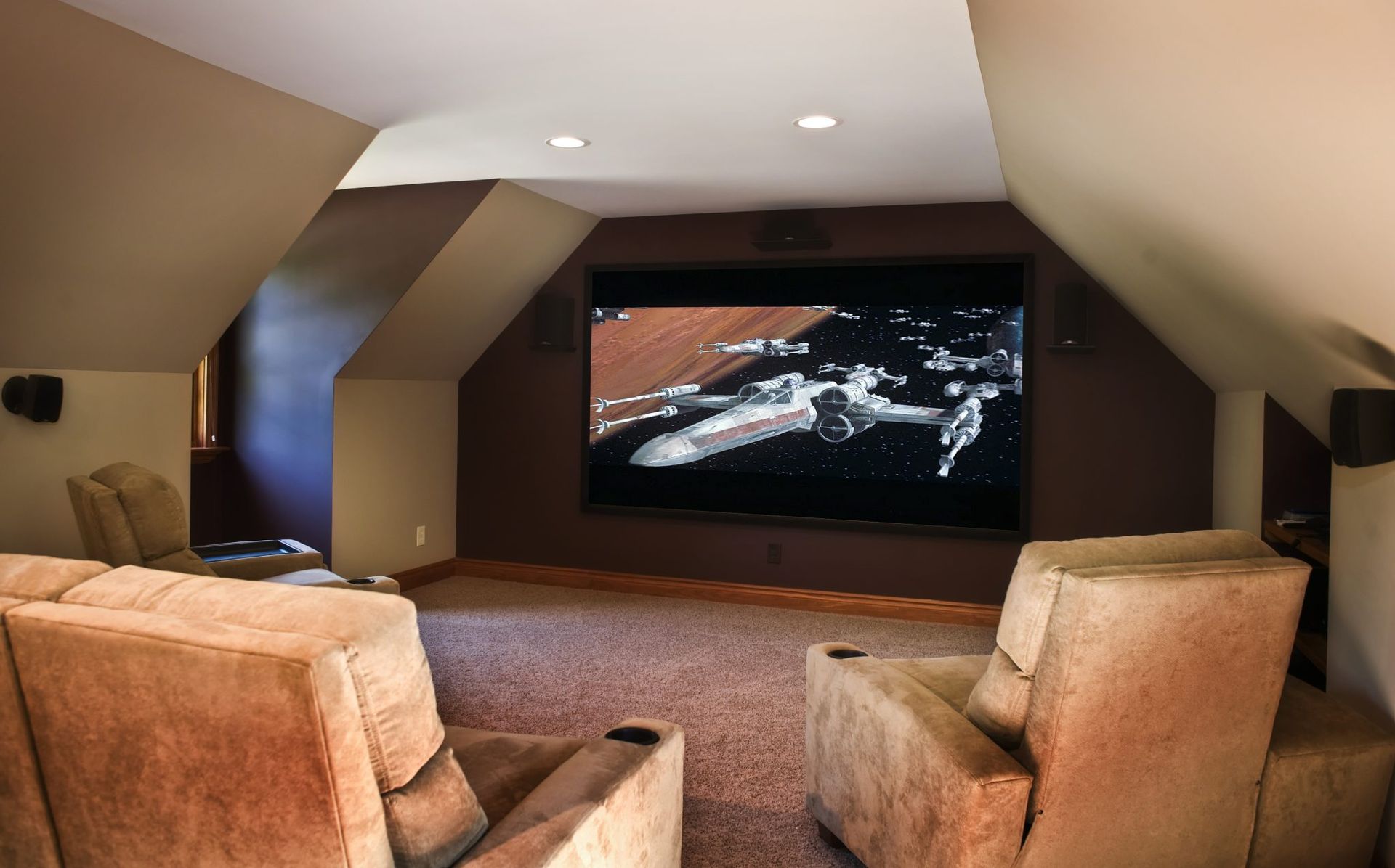 A home theater with a large screen and two chairs.