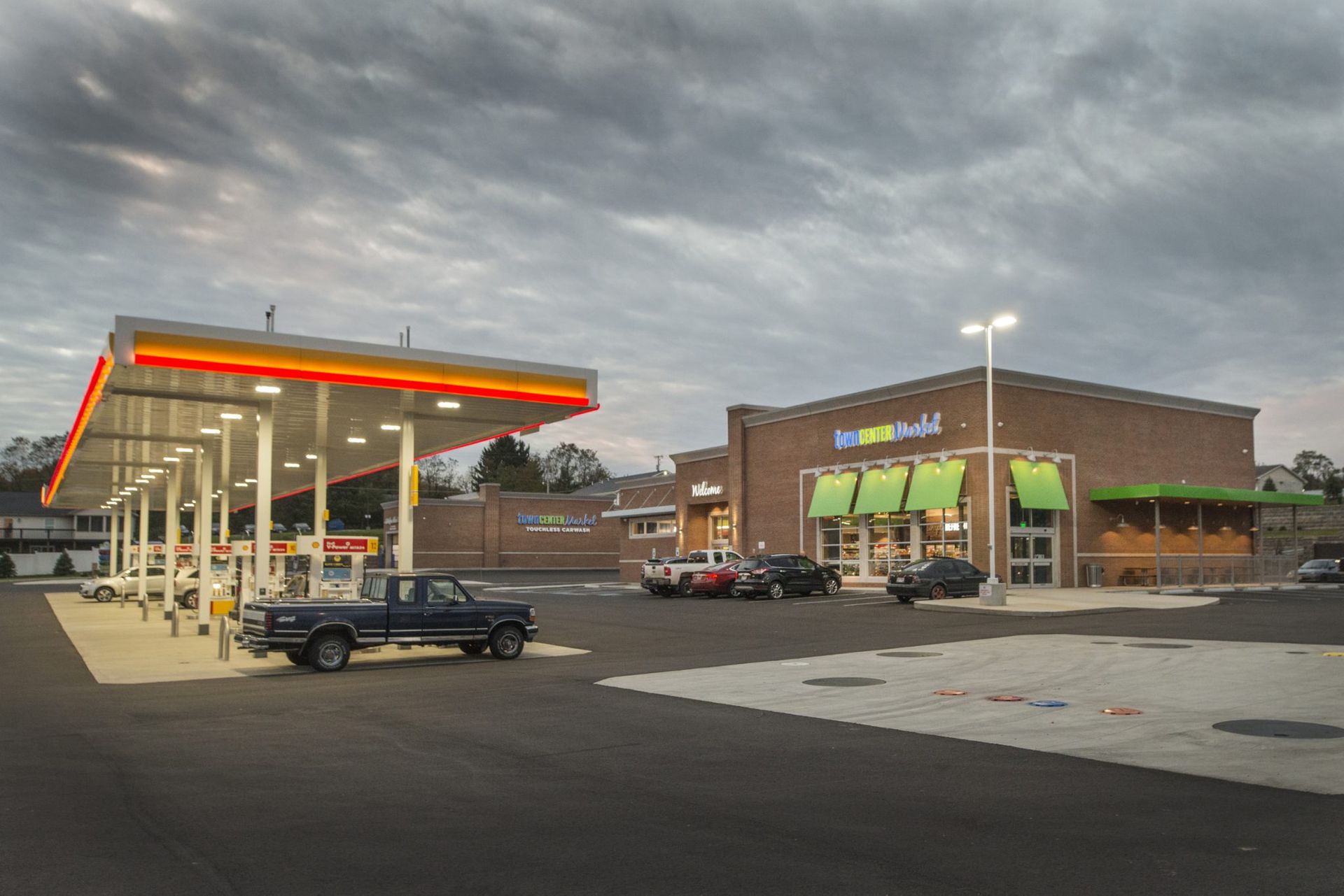 A truck is parked in front of a gas station.