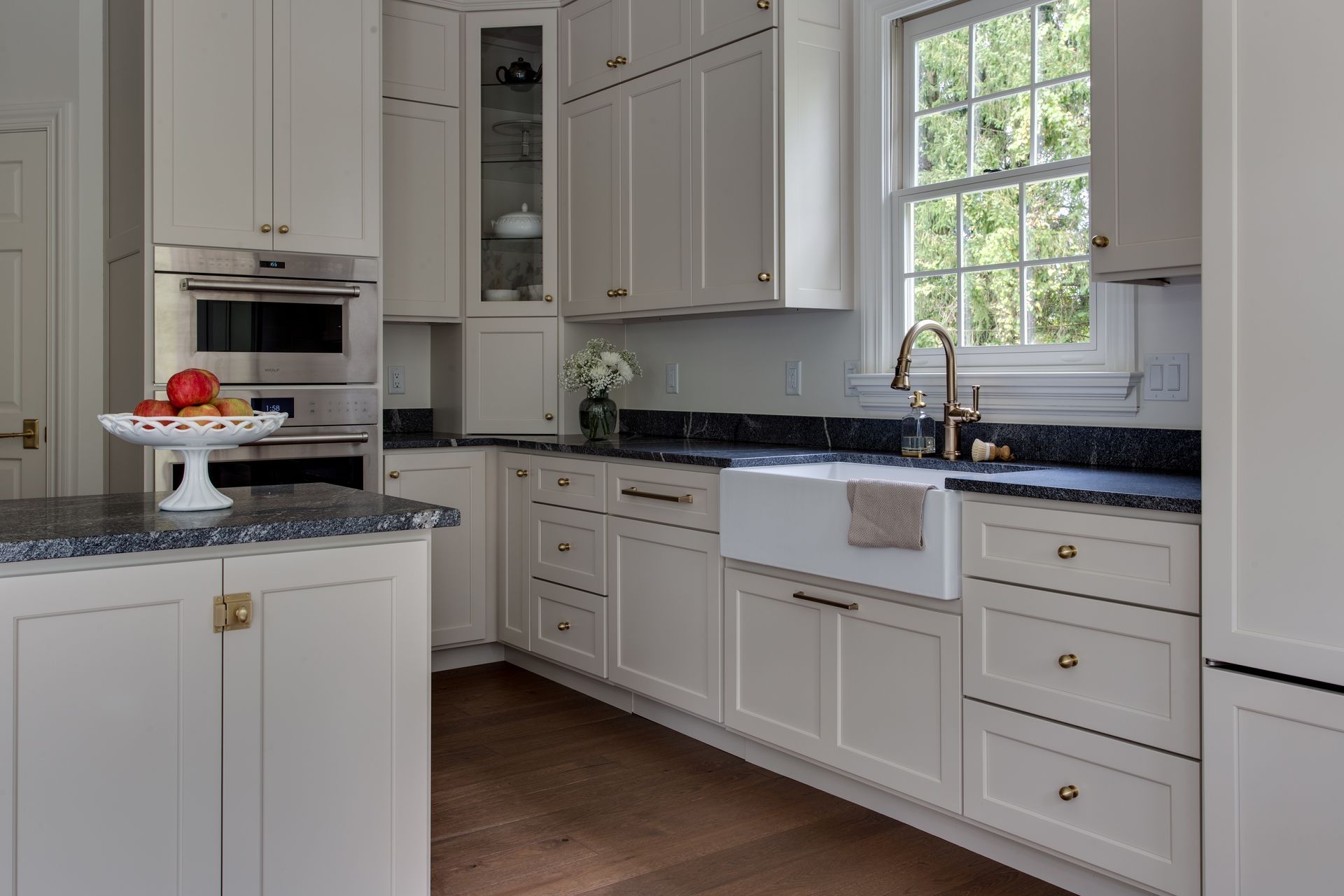 A kitchen with white cabinets and granite counter tops.