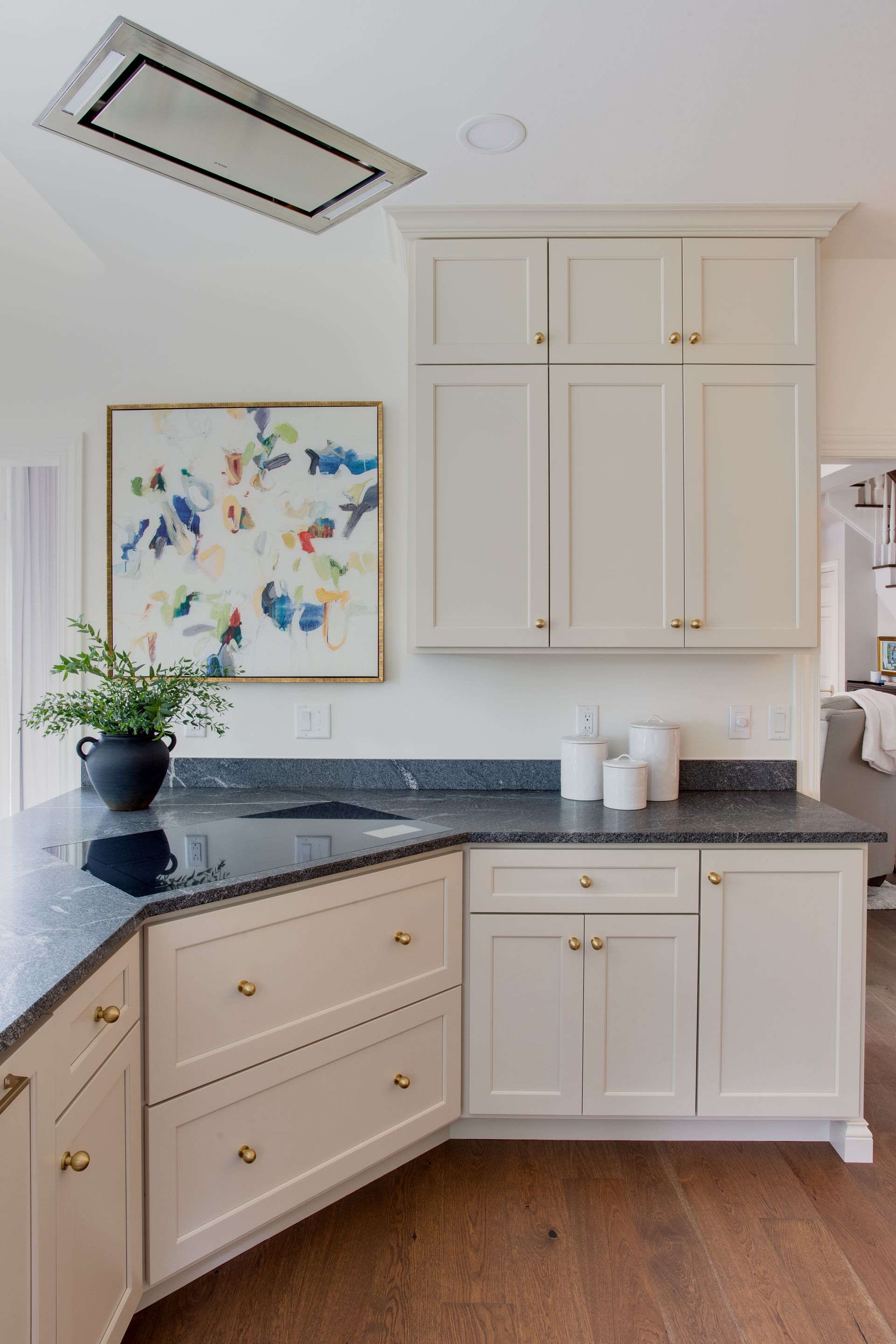 A kitchen with white cabinets and a black counter top.