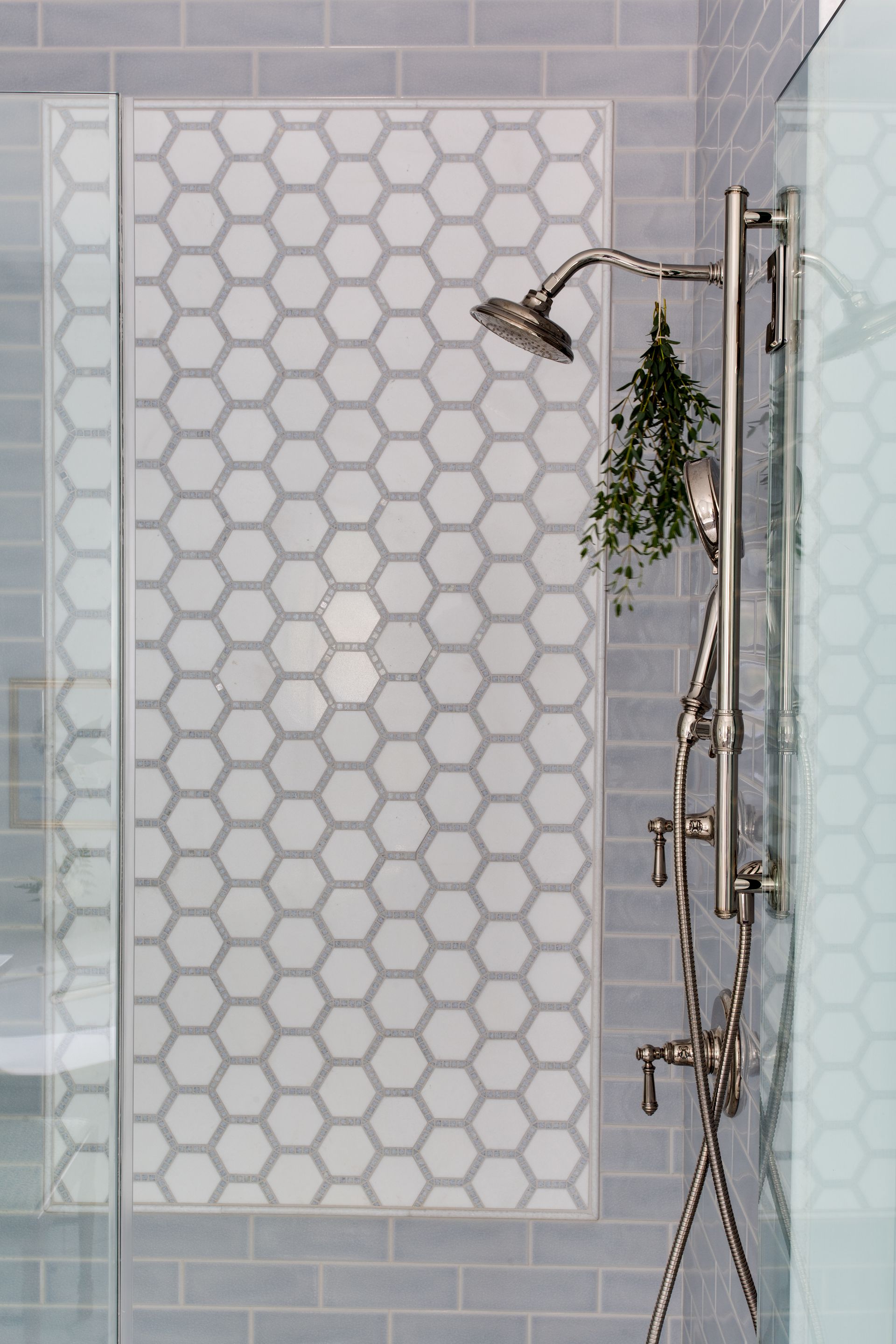 A shower with a shower head and a plant in it.