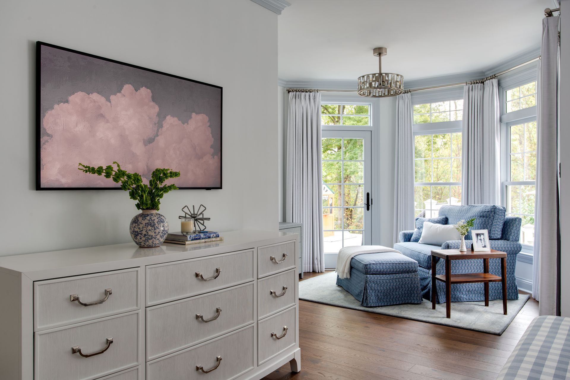 A living room with a dresser, couch, and ottoman.