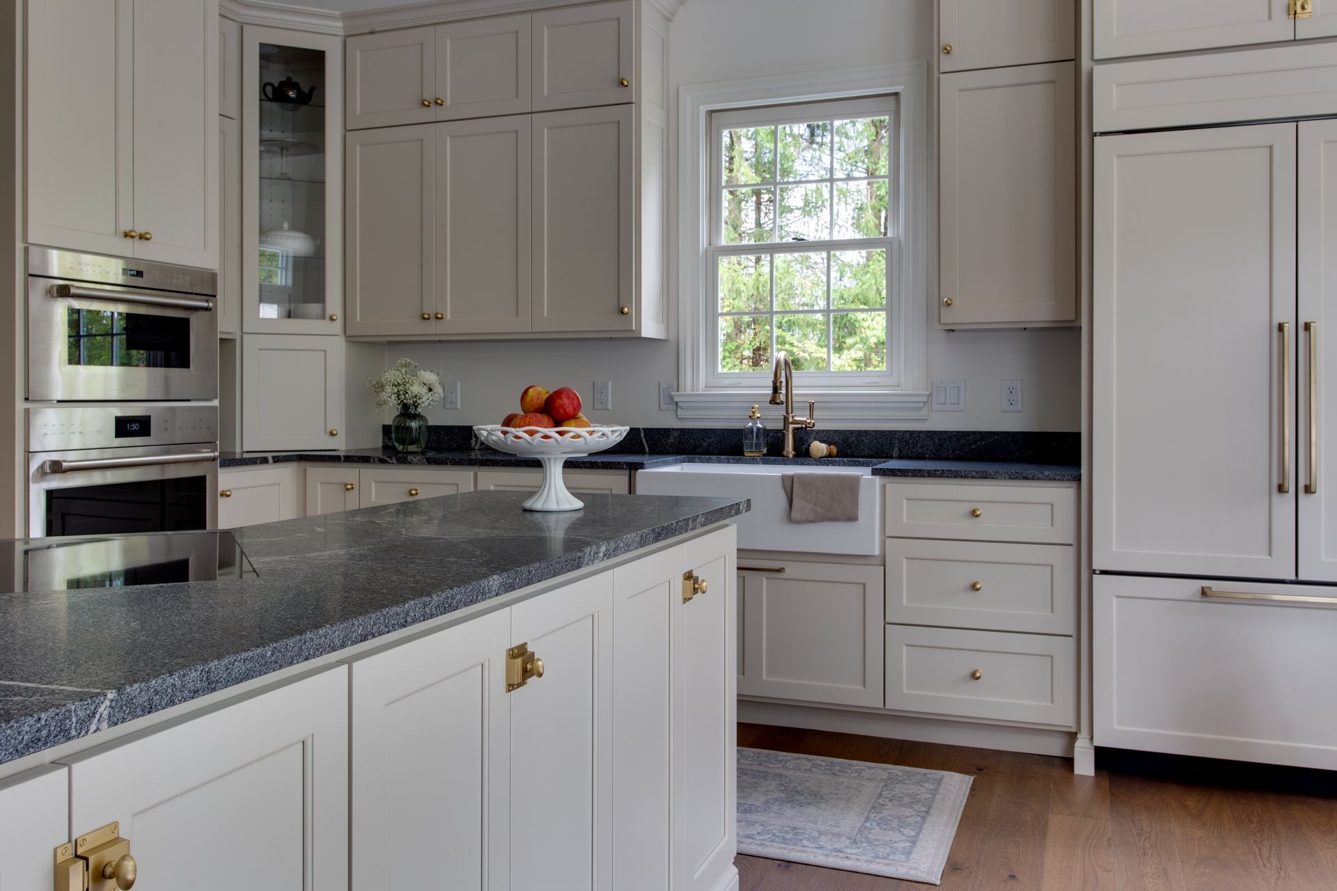 A kitchen with white cabinets and granite counter tops.