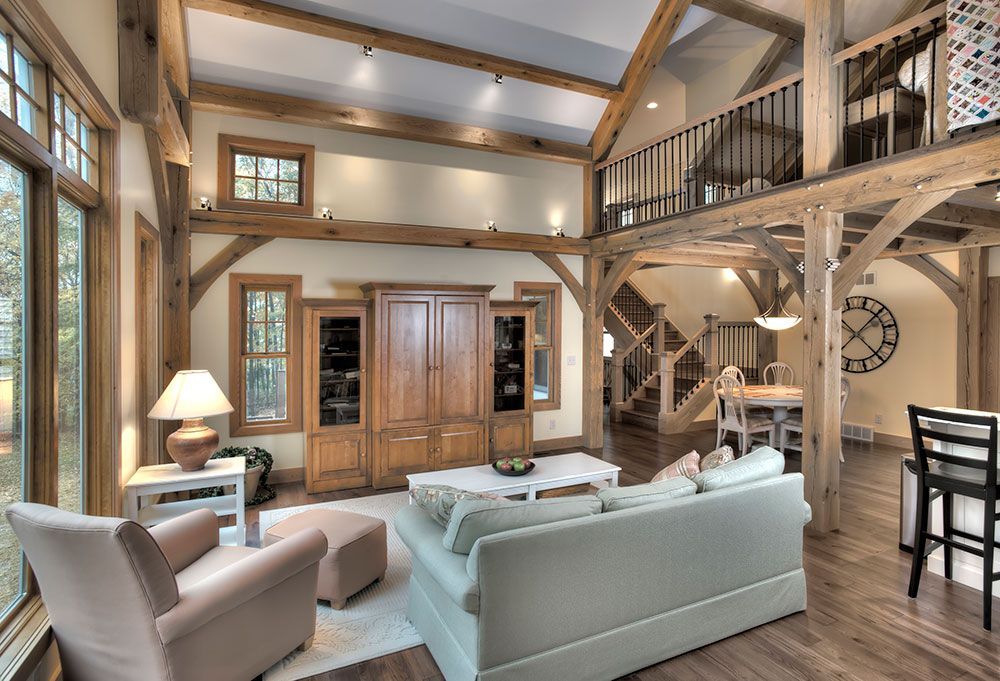A living room with a couch, chairs, and a clock on the wall.