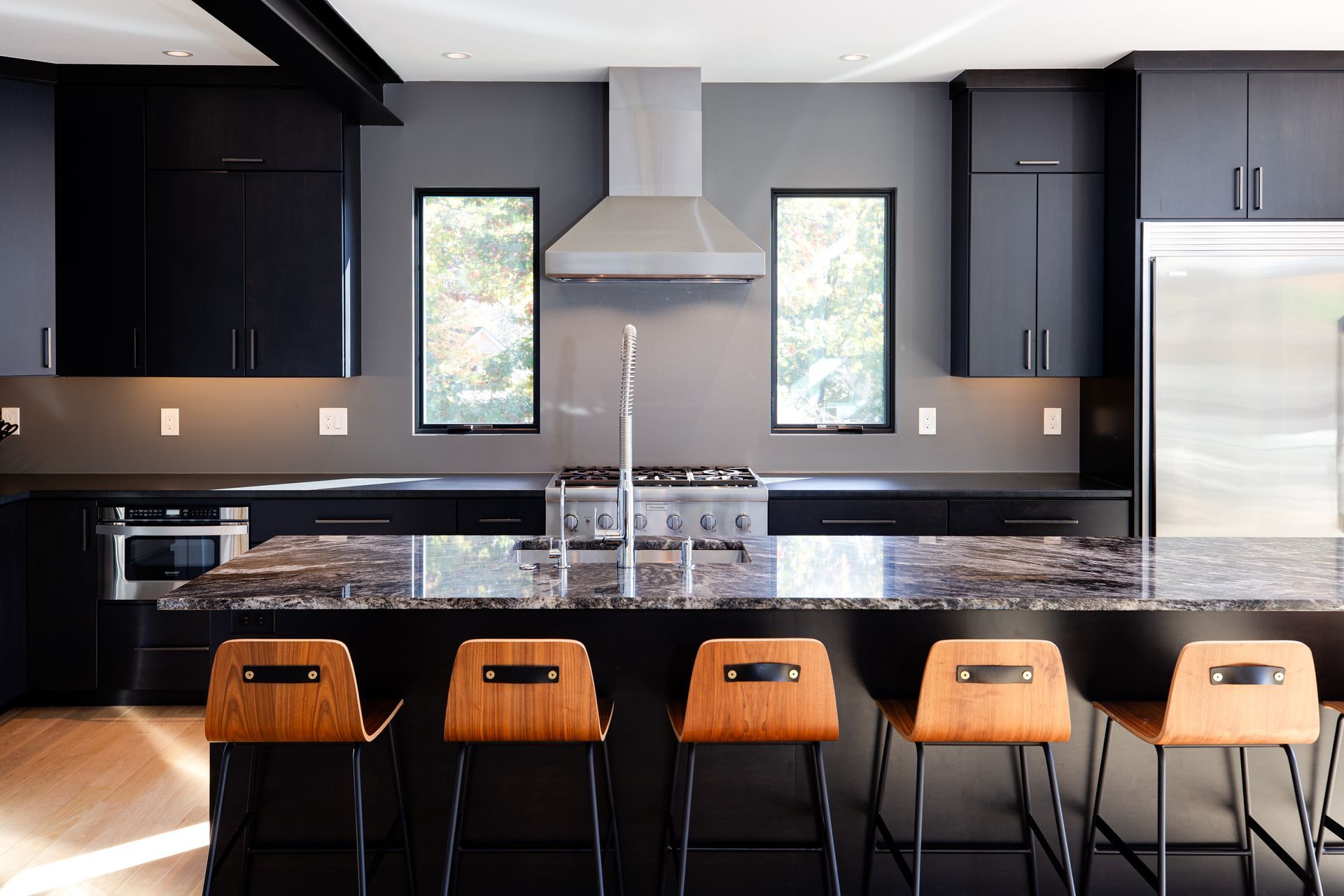A kitchen with black cabinets and stainless steel appliances.