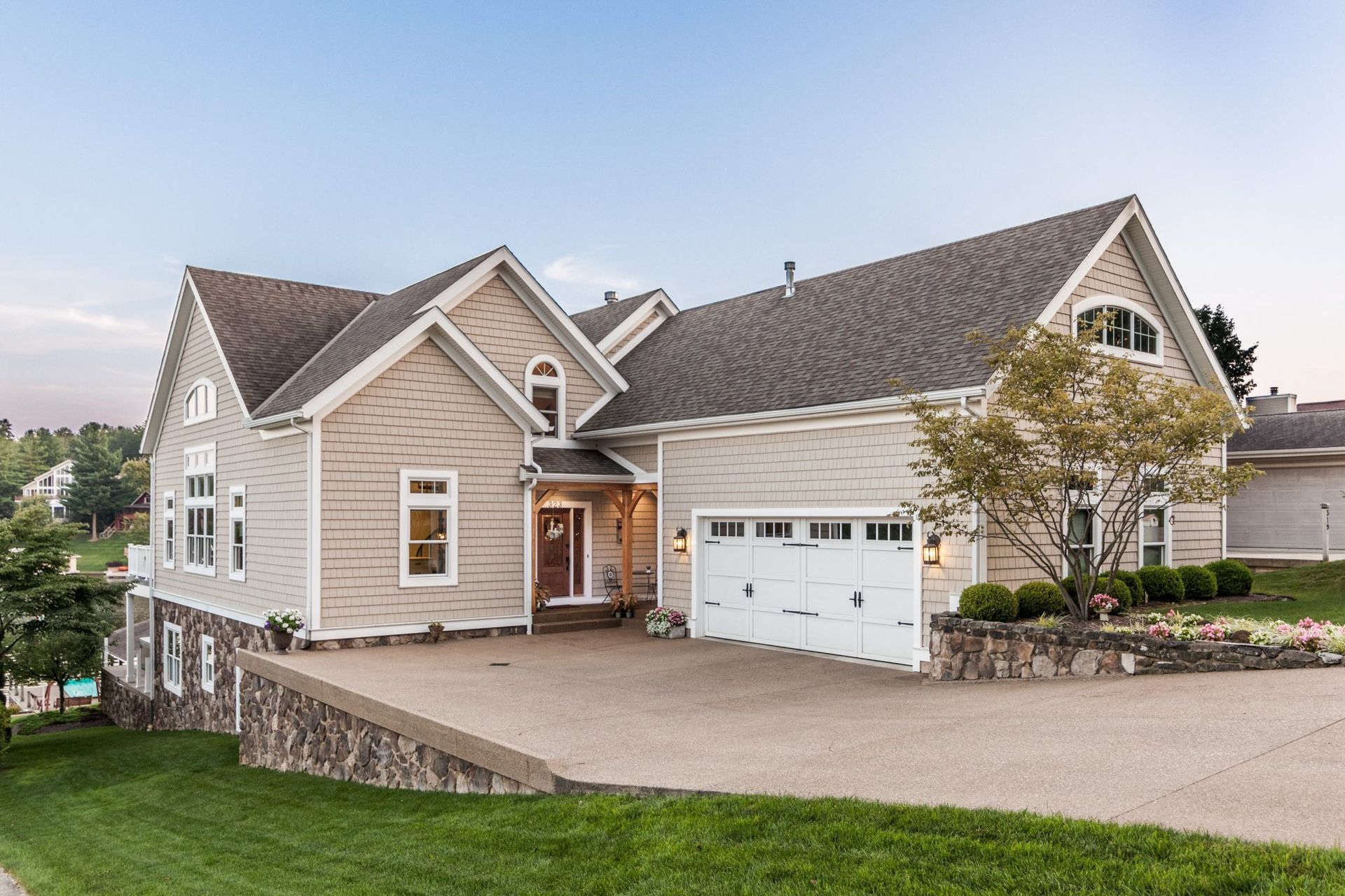 A large house with a large driveway and a large garage.