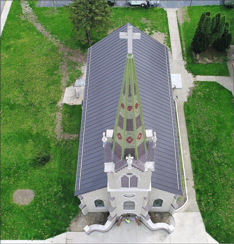 An aerial view of a church with a cross on top.