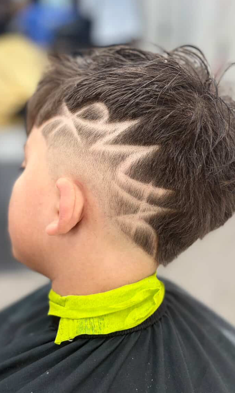 Close-up of a short haircut featuring a crown-shaped design shaved into the faded side.