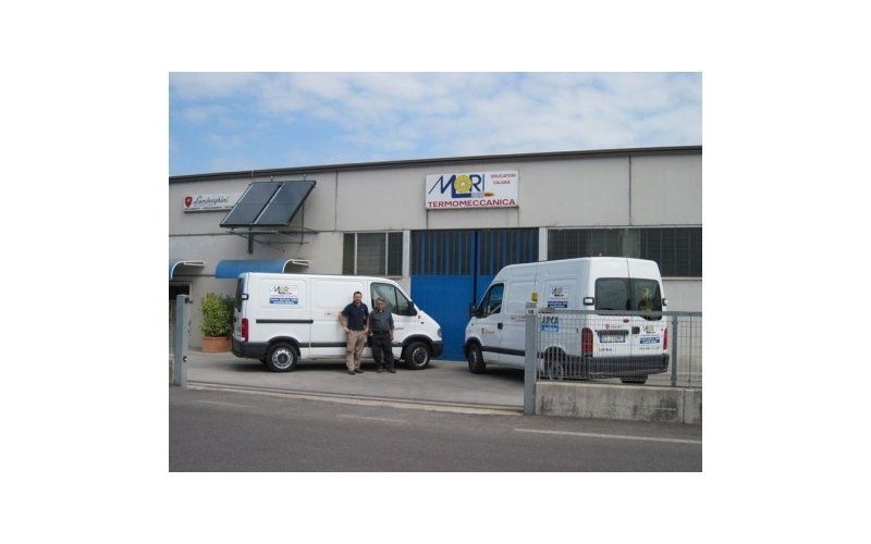 alcuni furgoni parcheggiati davanti a un impianto industriale