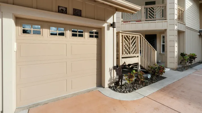 A house with a garage door and stairs leading up to it