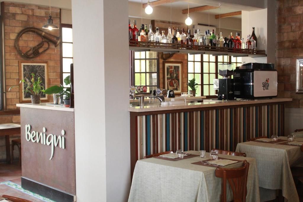 Due mini hamburger con patatine fritte su un piatto decorativo. Ingredienti: formaggio, sottaceti, pomodoro.