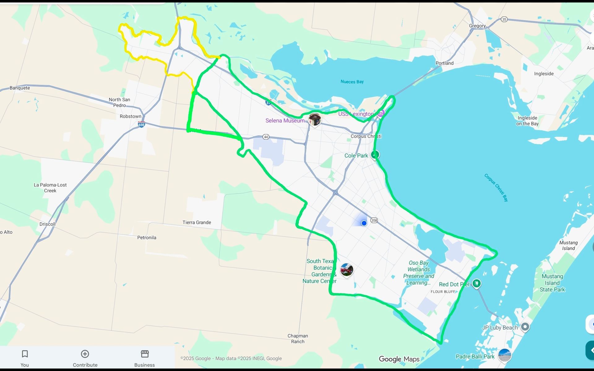 Map of a coastal area with a green route encircling the land, blue water on the right.