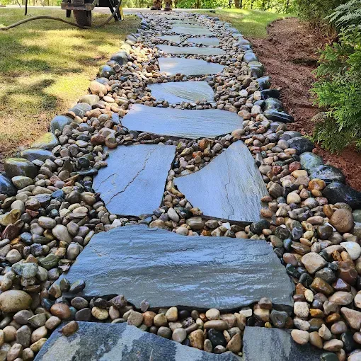 Stone path with large, flat stepping stones, surrounded by pebbles.