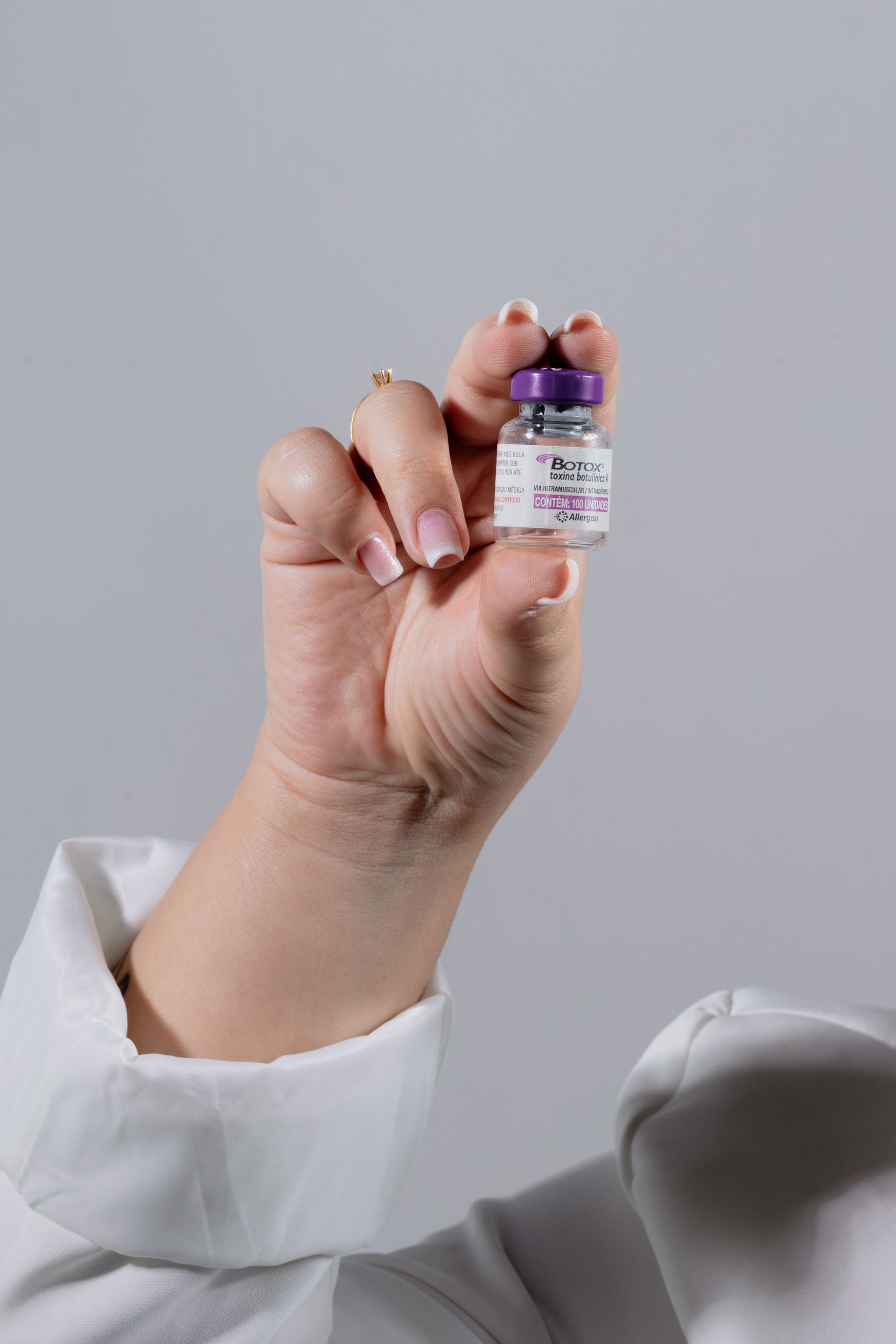 Nurse injector holding a small vial of botox