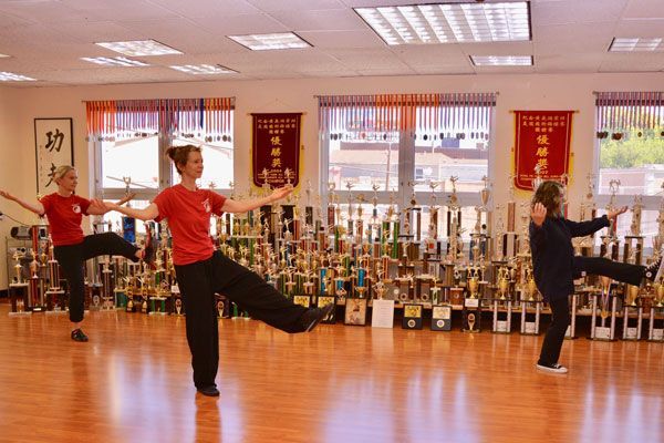 A group of women are practicing martial arts in a gym.