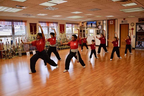 A group of children are practicing martial arts in a gym