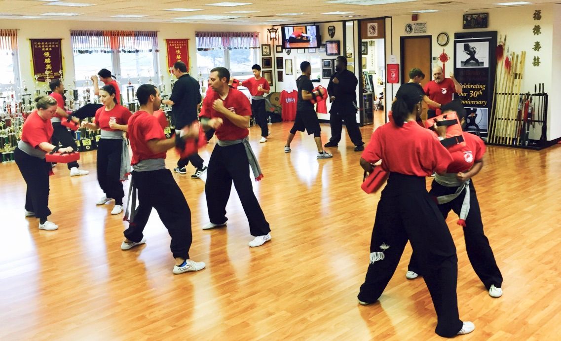 A group of people are practicing martial arts in a gym