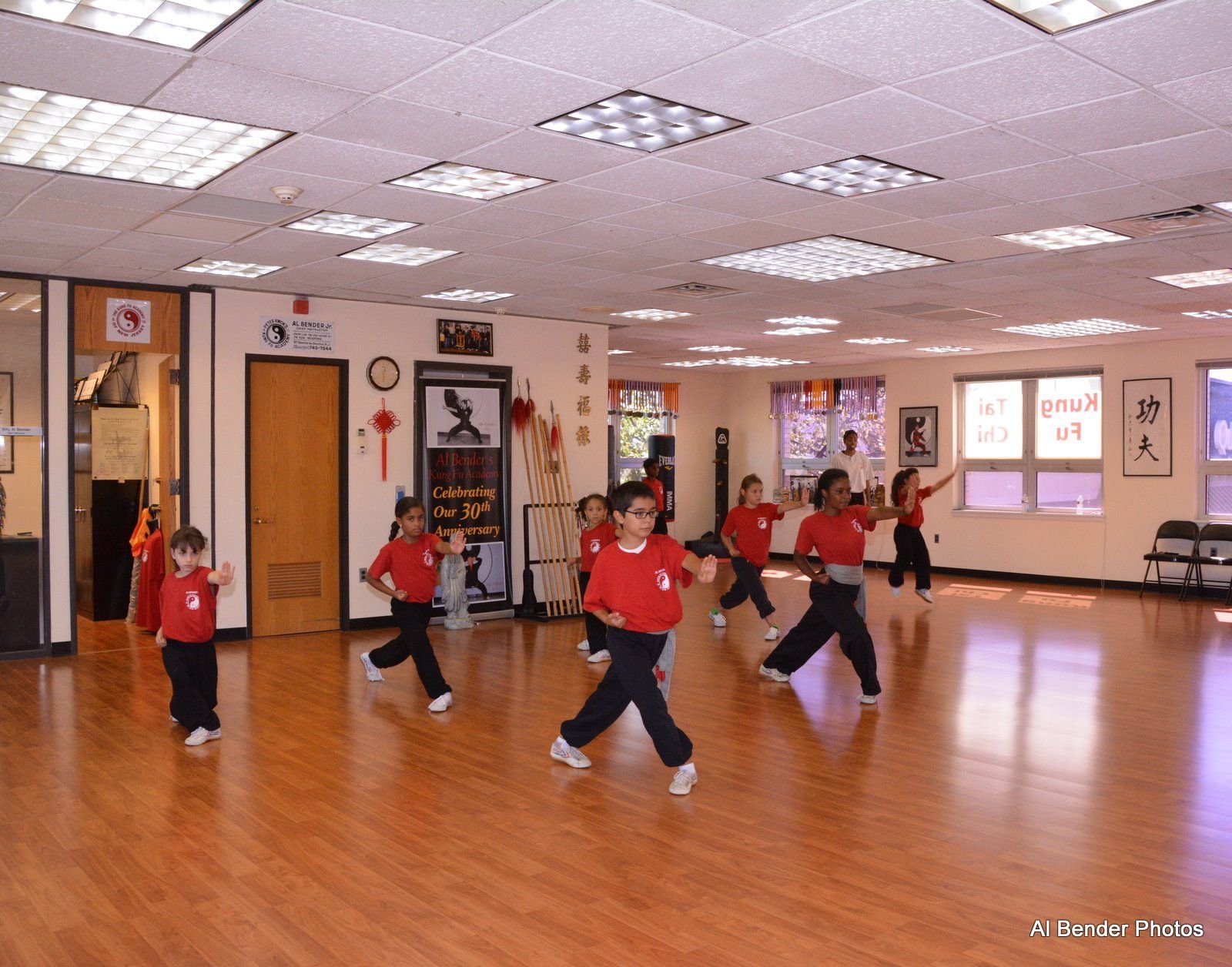 A group of children are practicing martial arts in a large room