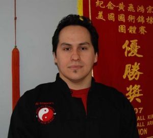A man stands in front of a red banner with chinese writing