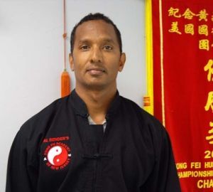 A man standing in front of a sign that says ' gong fei hua championships '