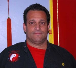 A man wearing a black jacket with the letter p on it