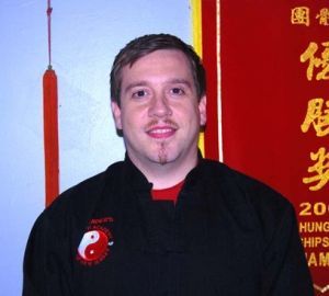A man wearing a black shirt with a yin yang symbol on it