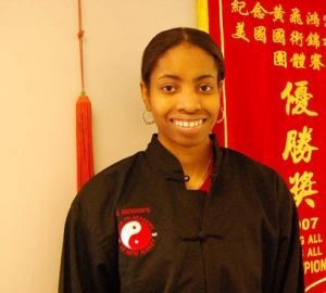 A woman stands in front of a sign that says all champions