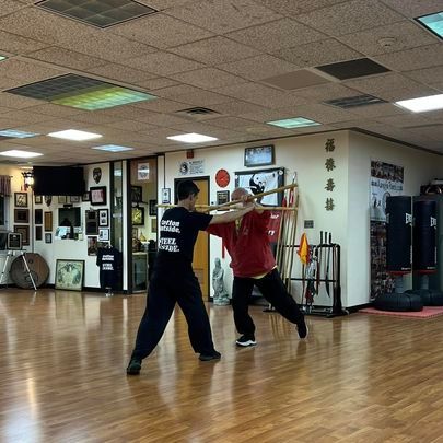 Two men are practicing martial arts in a gym