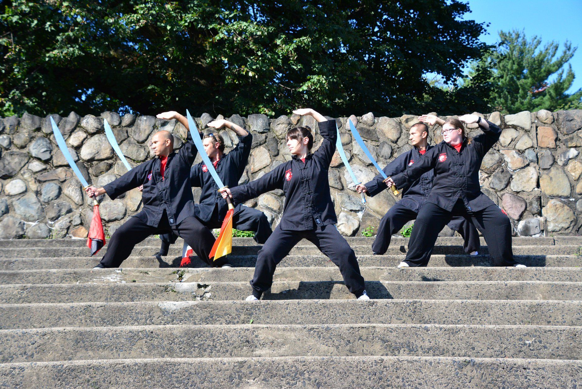 A group of people are practicing martial arts on a set of stairs.