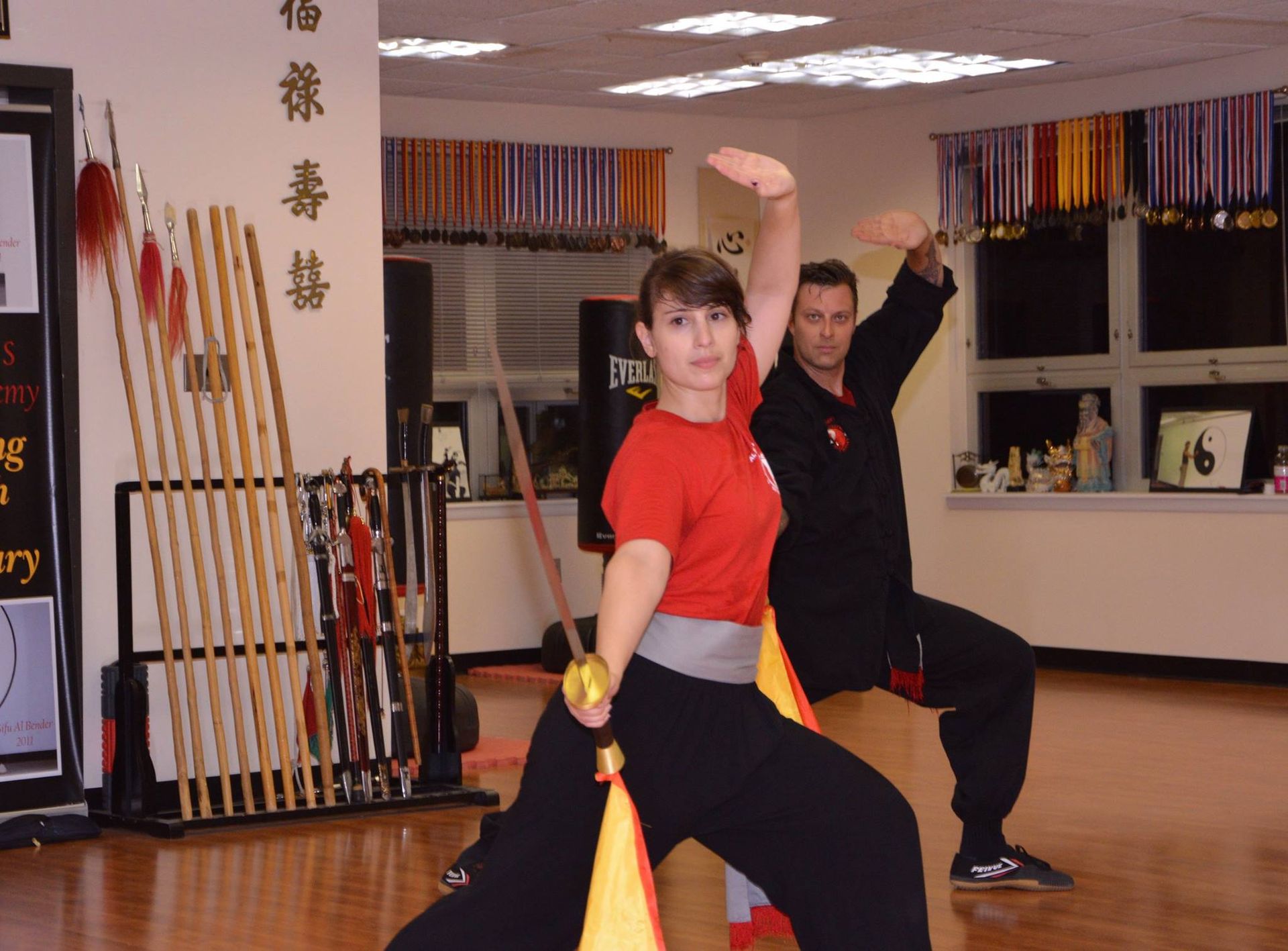 A man and a woman are practicing martial arts in a gym