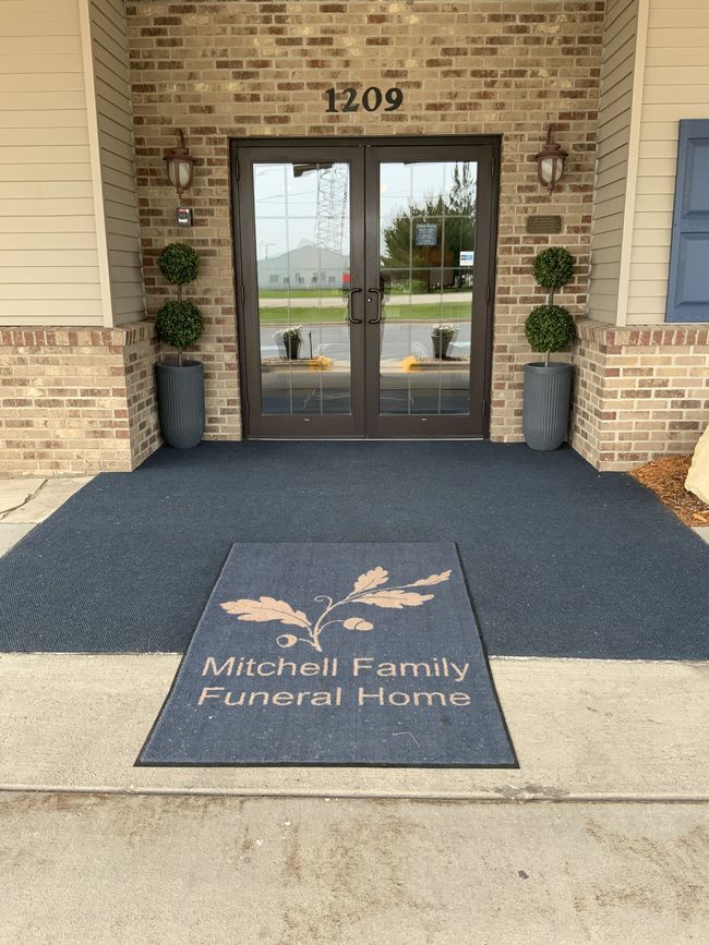 A funeral home with a black awning over the door