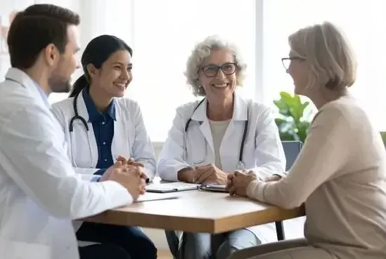 3 doctors smiling around a table