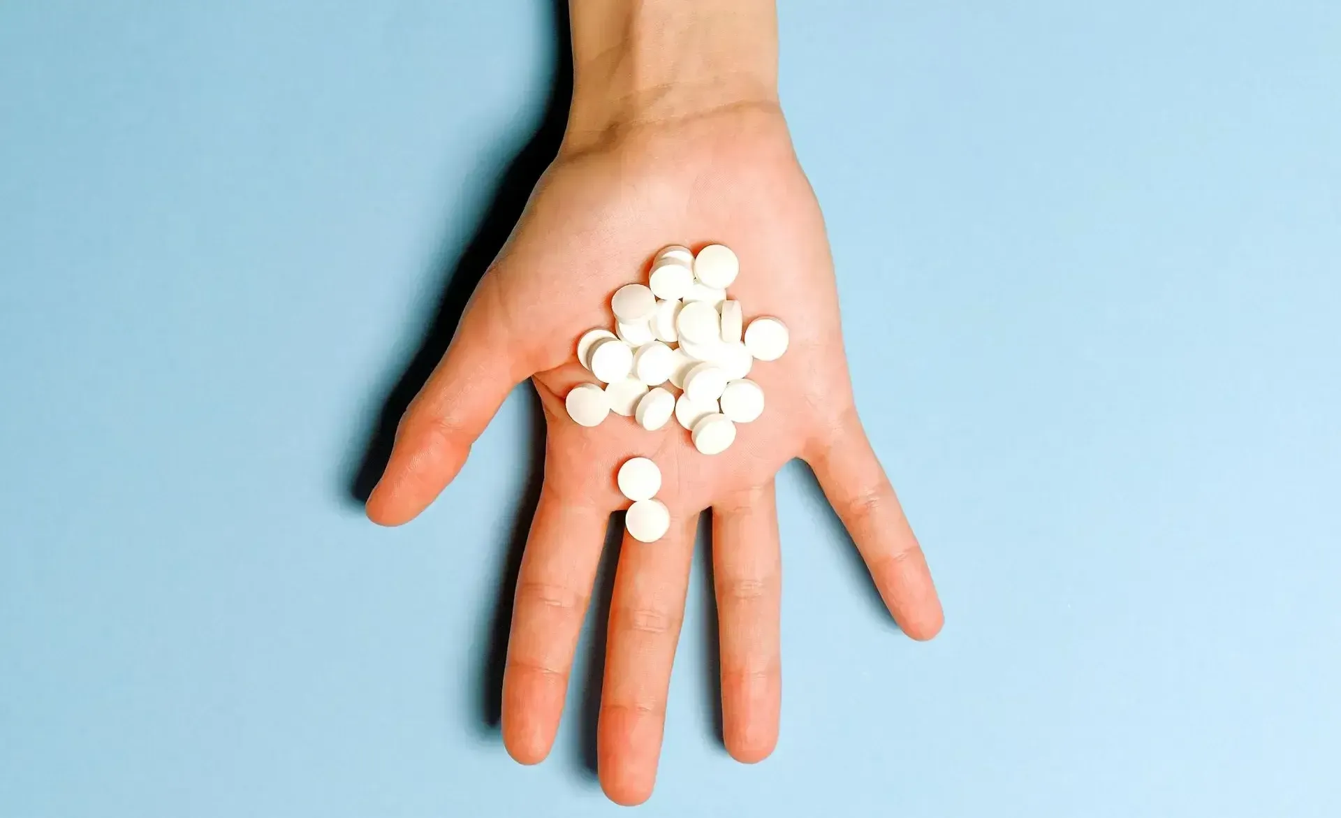 hand holding white tablets