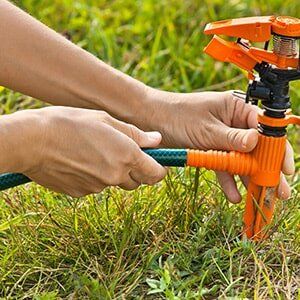 Gardener installing lawn sprinkler - Home Plumbing Inspection in Cheyenne, WY