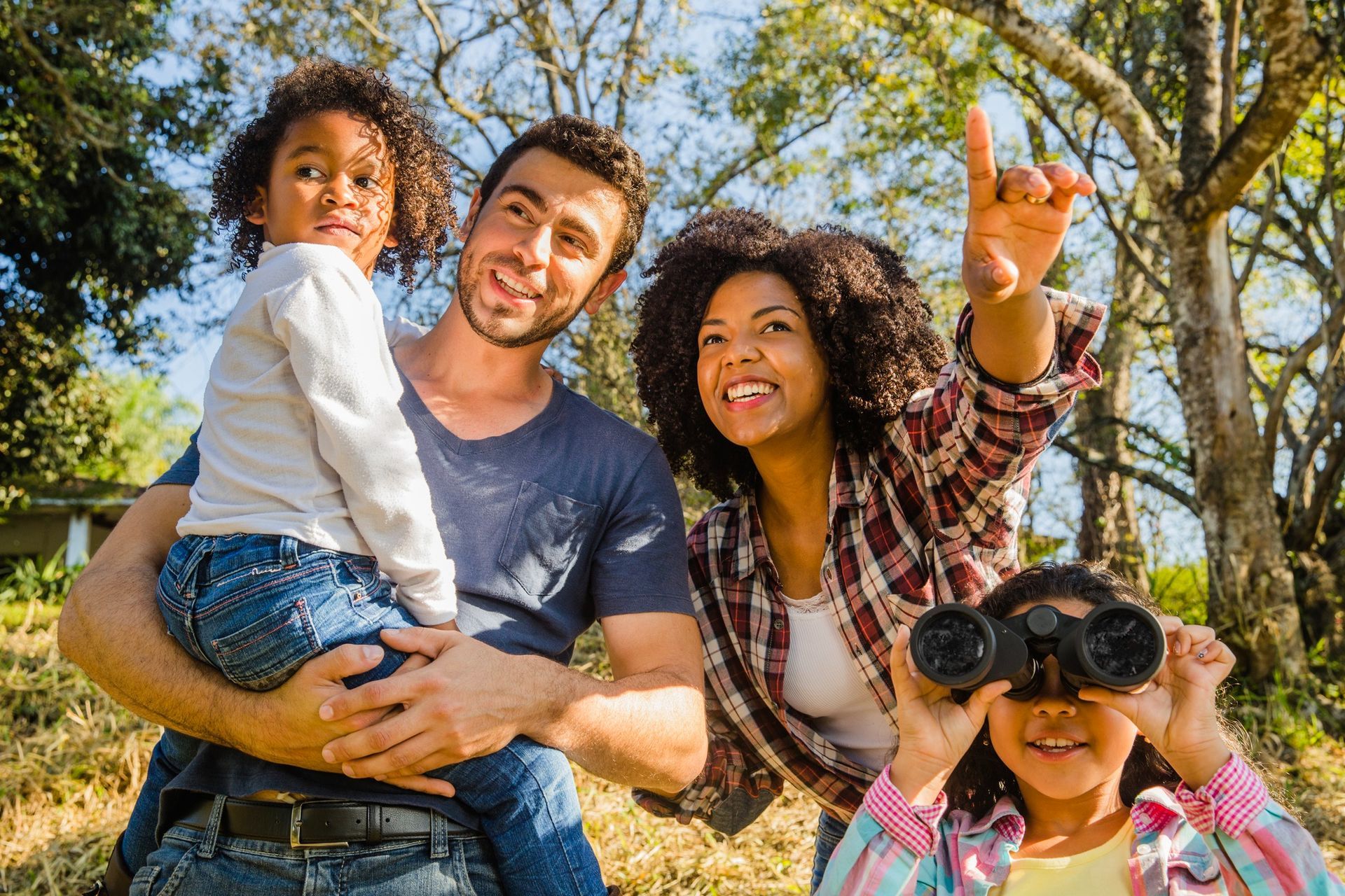 A family is looking through binoculars in a park.