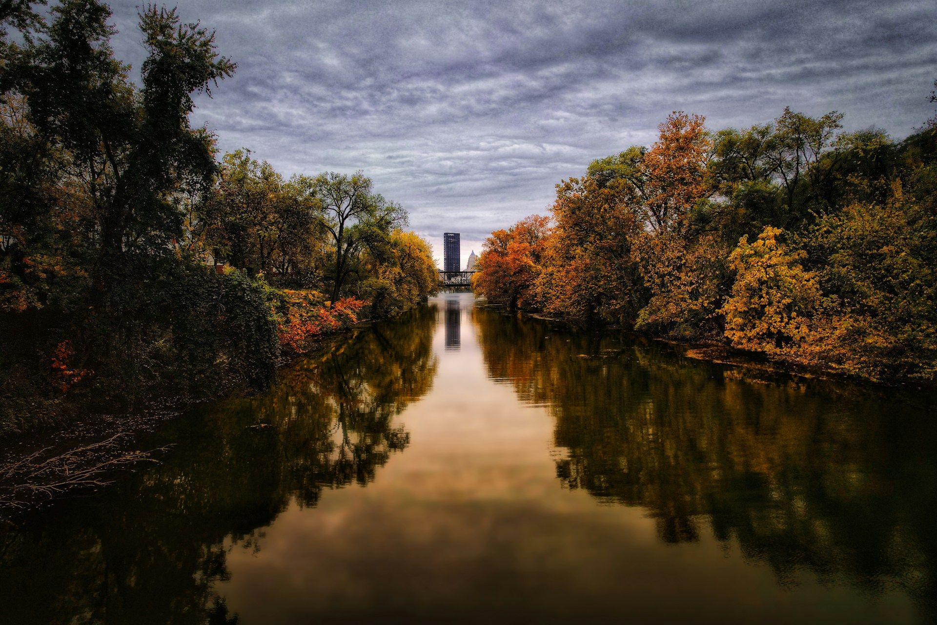 A river surrounded by trees on a cloudy day