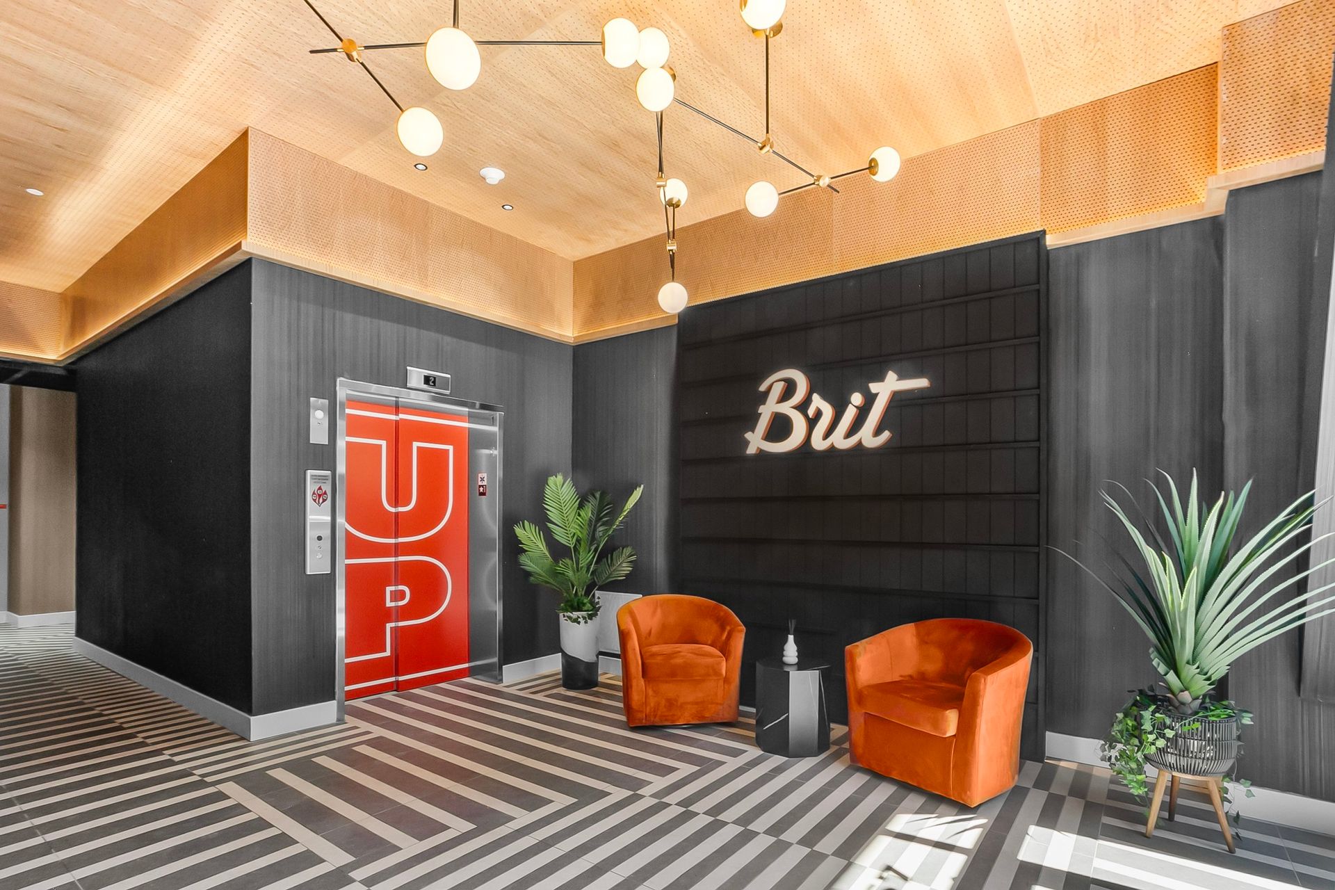 Lobby with orange armchairs, elevator with