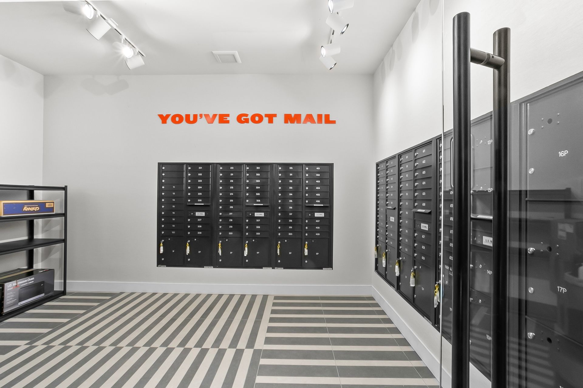 Mailroom with black mailboxes and striped floor,