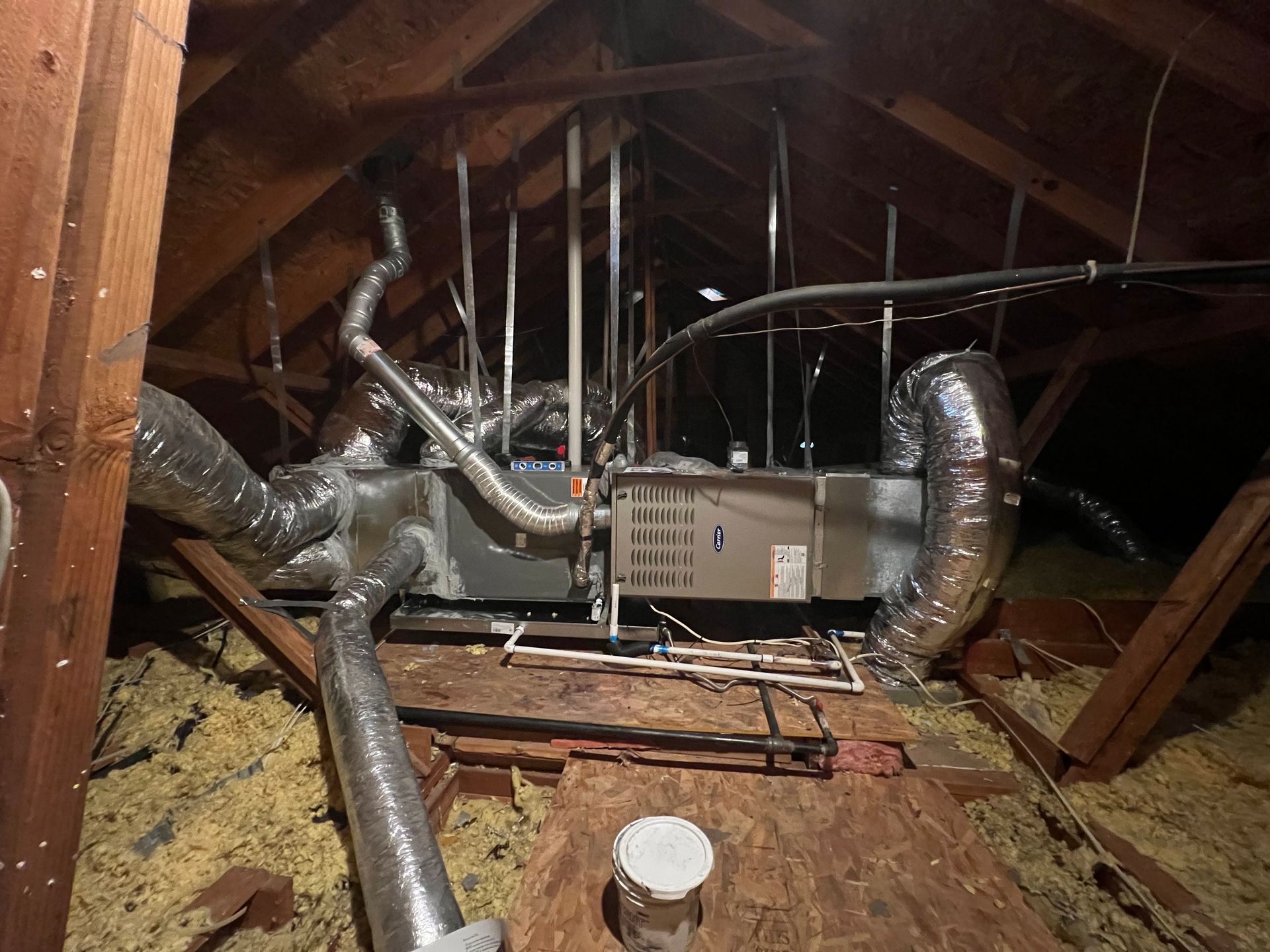 An air conditioner is sitting in the attic of a house.