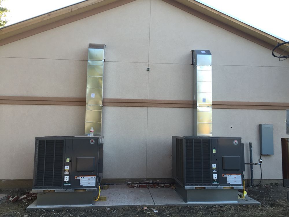 Two air conditioners on the side of a building