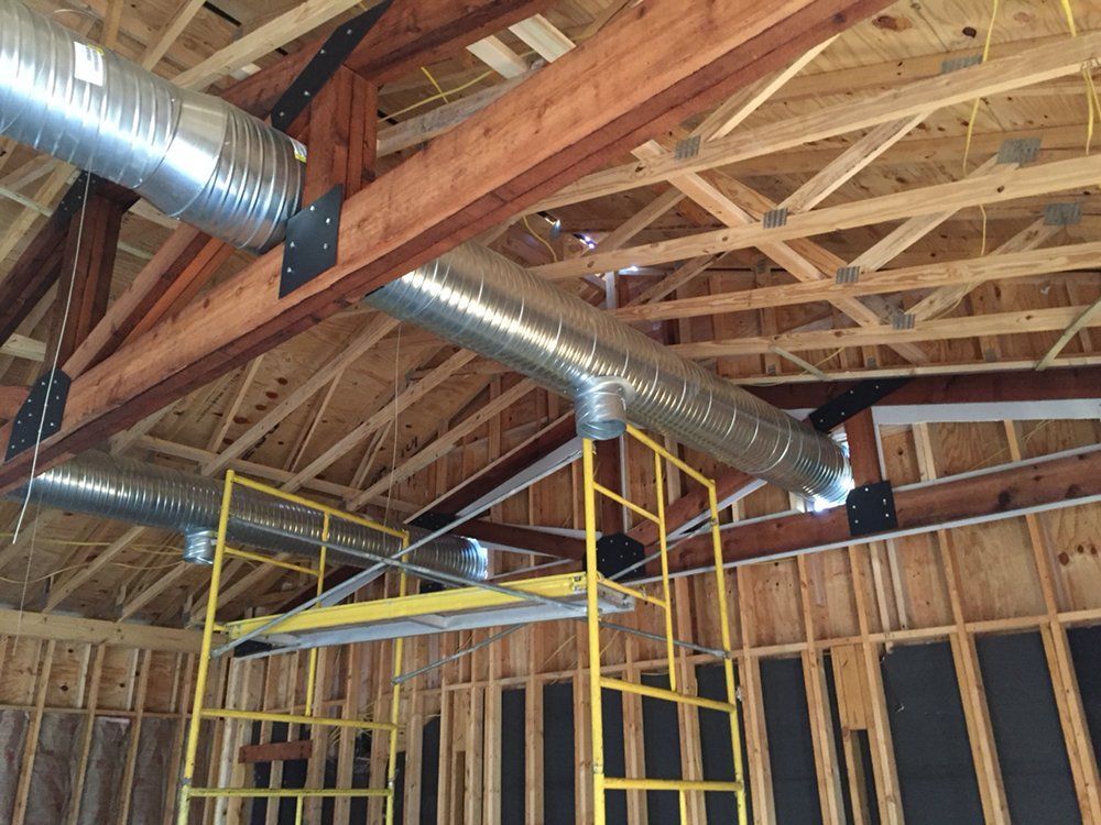 The ceiling of a building under construction with a scaffolding in the foreground.