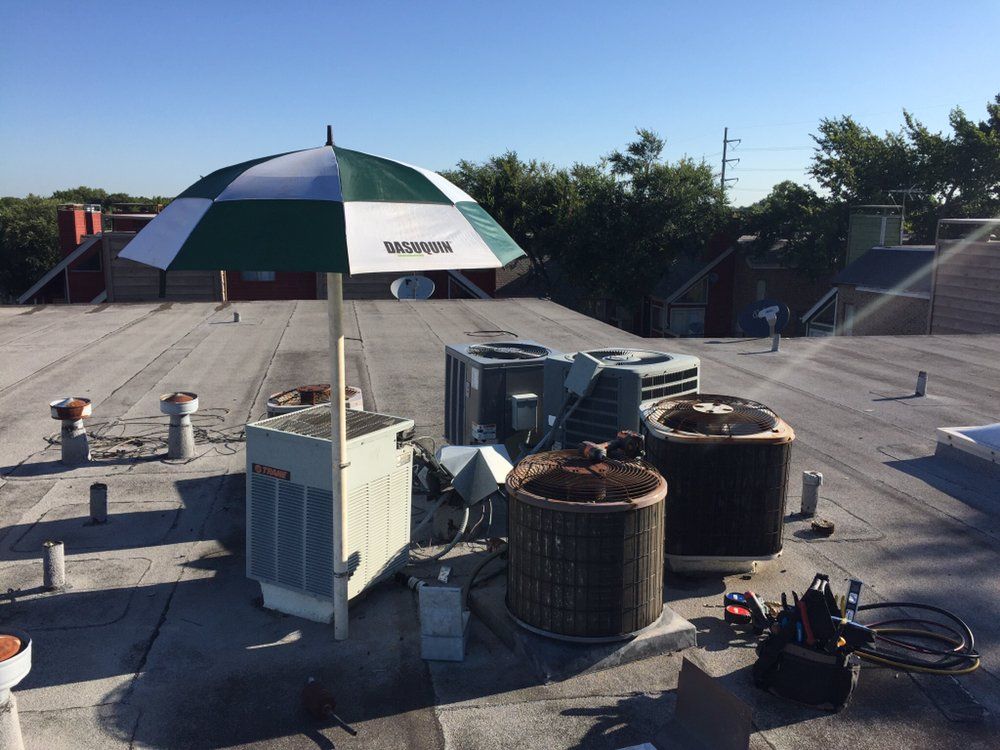 A green and white umbrella is sitting on top of a roof.