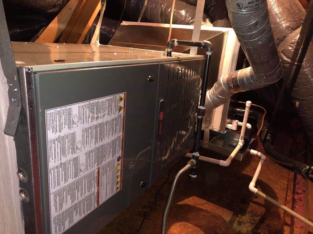 An air conditioner is sitting in the attic of a house.