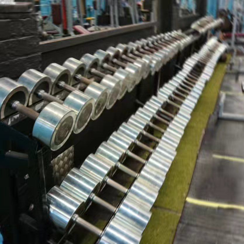 A row of dumbbells are lined up in a gym