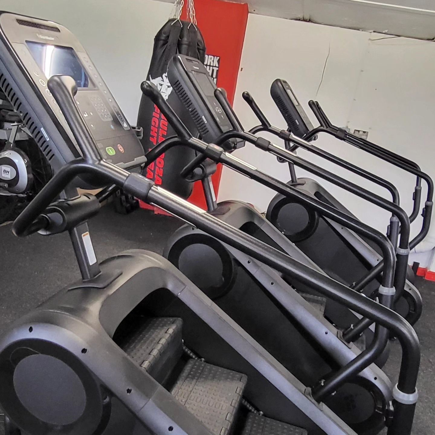 A row of treadmills are lined up in a gym