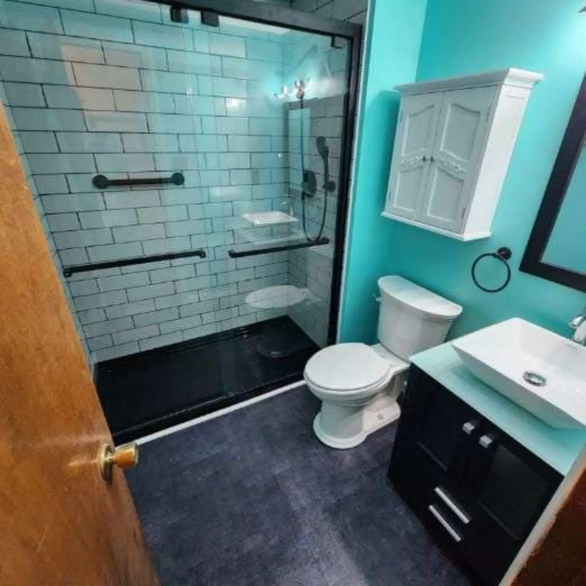 The 5 Contracting- A bathroom with a toilet , sink and shower.