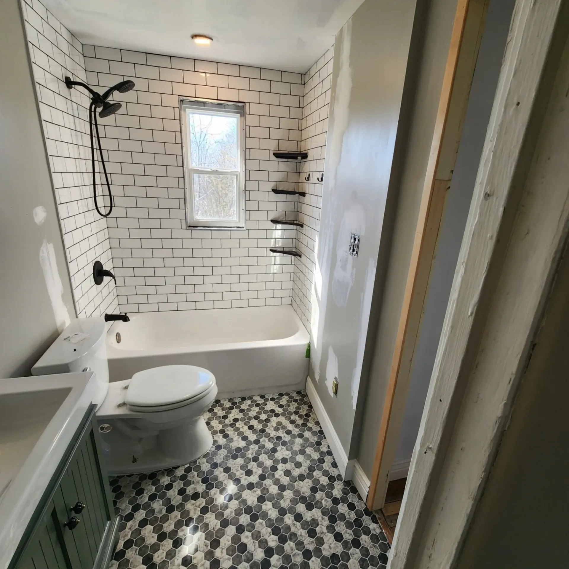 The 5 Contracting- A bathroom with a toilet , sink , bathtub and shower.