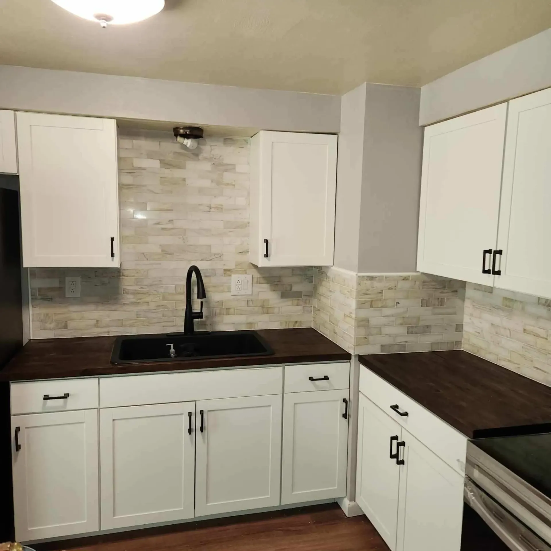 The 5 Contracting- A kitchen with white cabinets and a sink