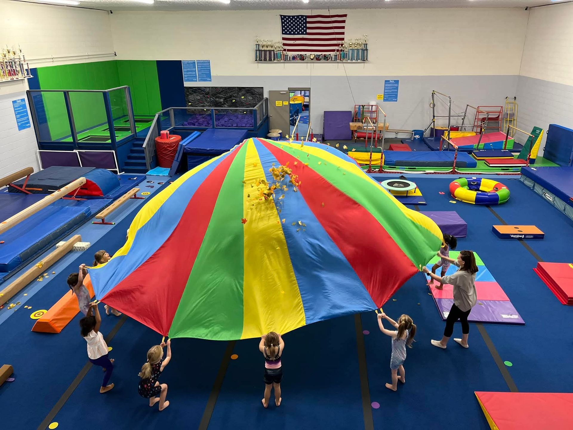A young boy in an orange shirt is climbing a rope