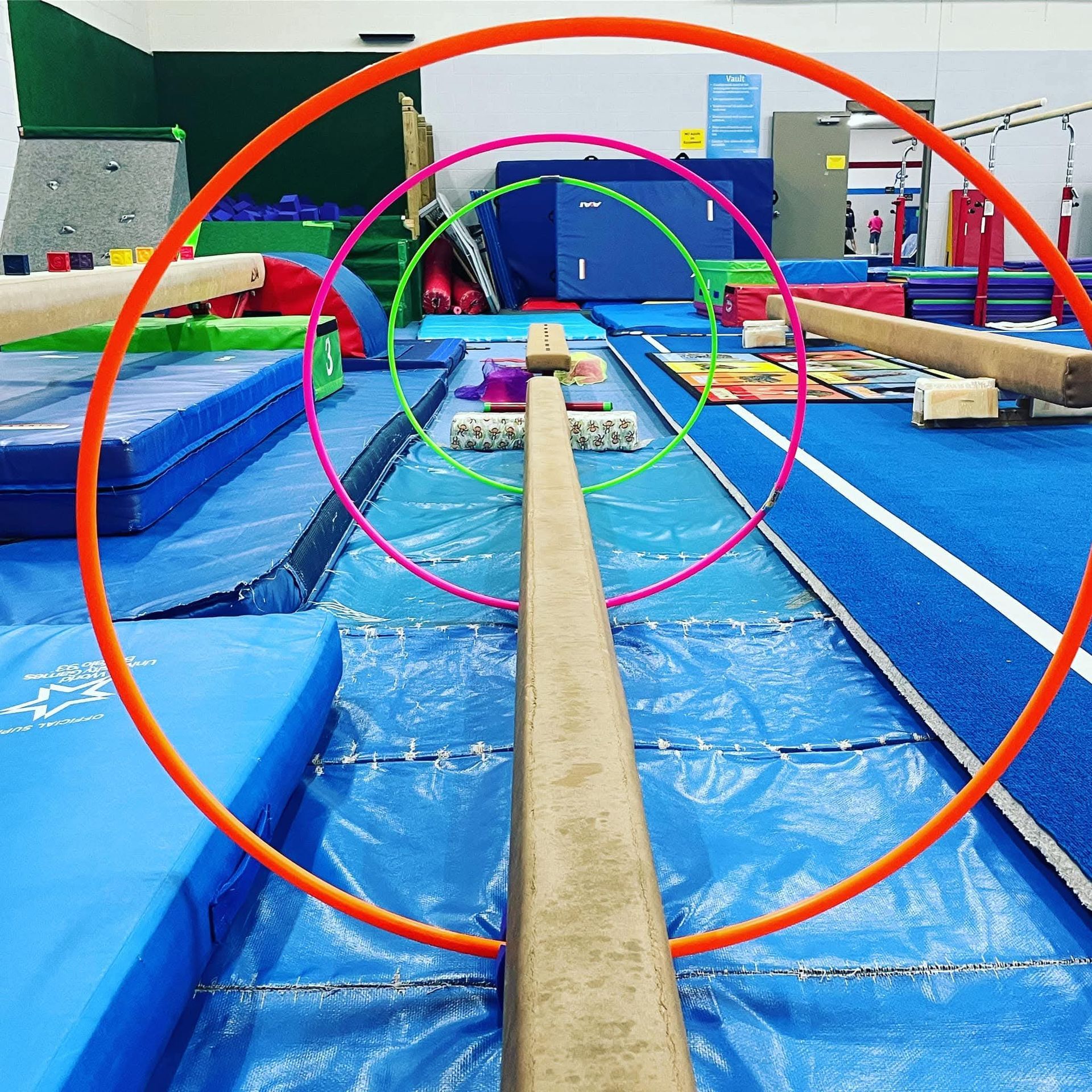 A young boy wearing a helmet is walking across a ropes course.